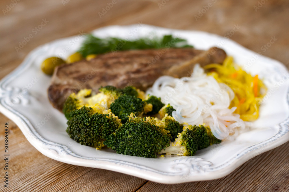 Grilled cooked beef meat, broccoli, vegetable spaghetti shirataki, olives ketogenic diet dish Grilled cooked beef meat, broccoli, vegetable spaghetti shirataki, olives ketogenic diet dish