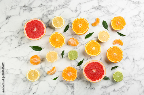 Flat lay composition with tangerines and different citrus fruits on white marble background