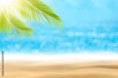 Blur beautiful nature green palm leaf on tropical beach with bokeh sun light wave abstract background.