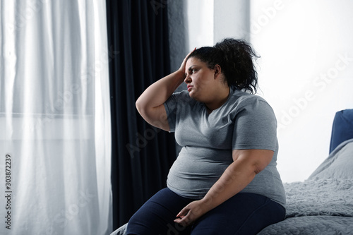 Tablou pe pânză Depressed overweight woman on bed at home