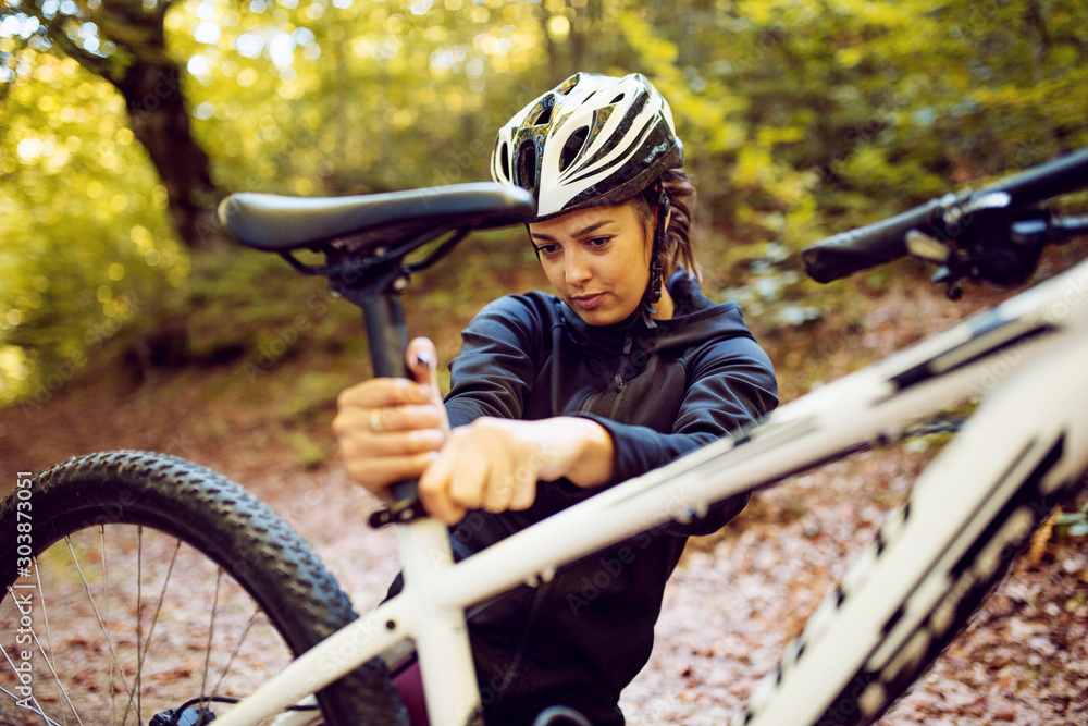 Naklejka premium Woman cyclist set up bicycle seat