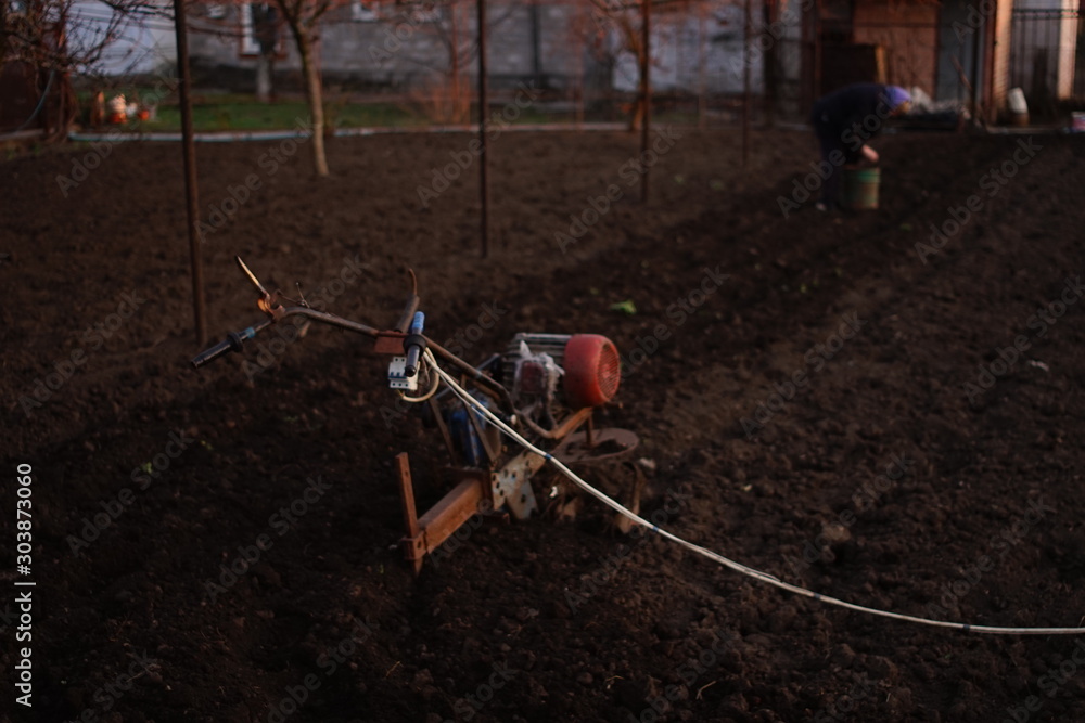 Homemade tiller for plowing the soil. Cultivator for cultivating the land. A villager is planting potatoes.
