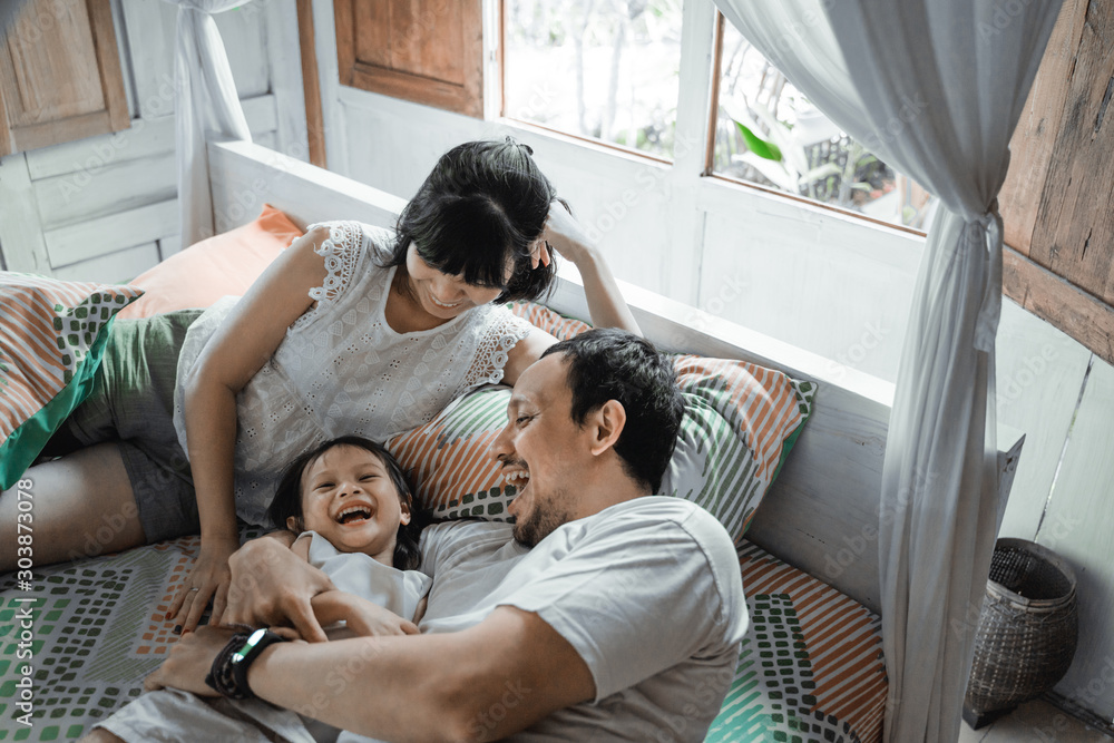 Happy family playing together on the bed enjoy the day Happy family playing together on the bed enjoy the day
