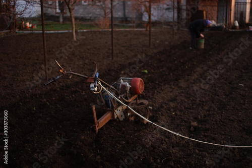 Homemade tiller for plowing the soil. Cultivator for cultivating the land. A villager is planting potatoes. © Omega