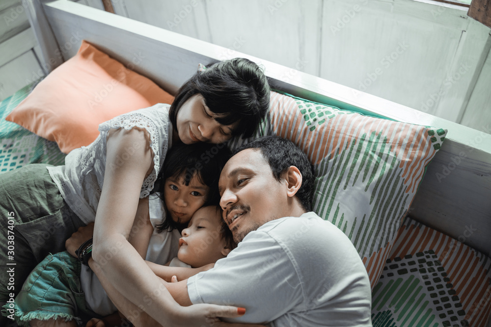 Happy family playing together on the bed enjoy the day Happy family playing together on the bed enjoy the day