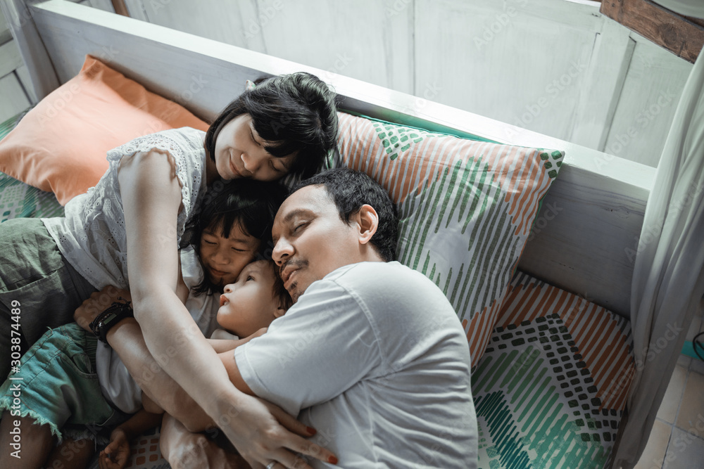 Φωτογραφία Asian happy family and child daughter relaxing on the bed enjoy holiday