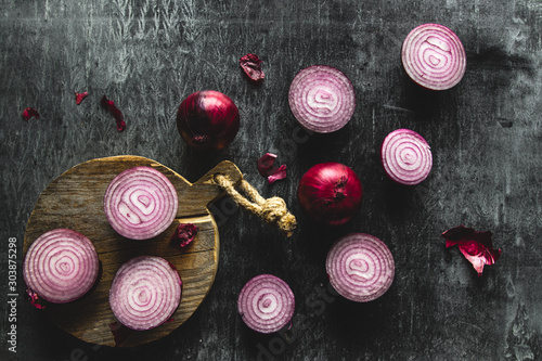 Red Onion Slices on wooden board with dark background