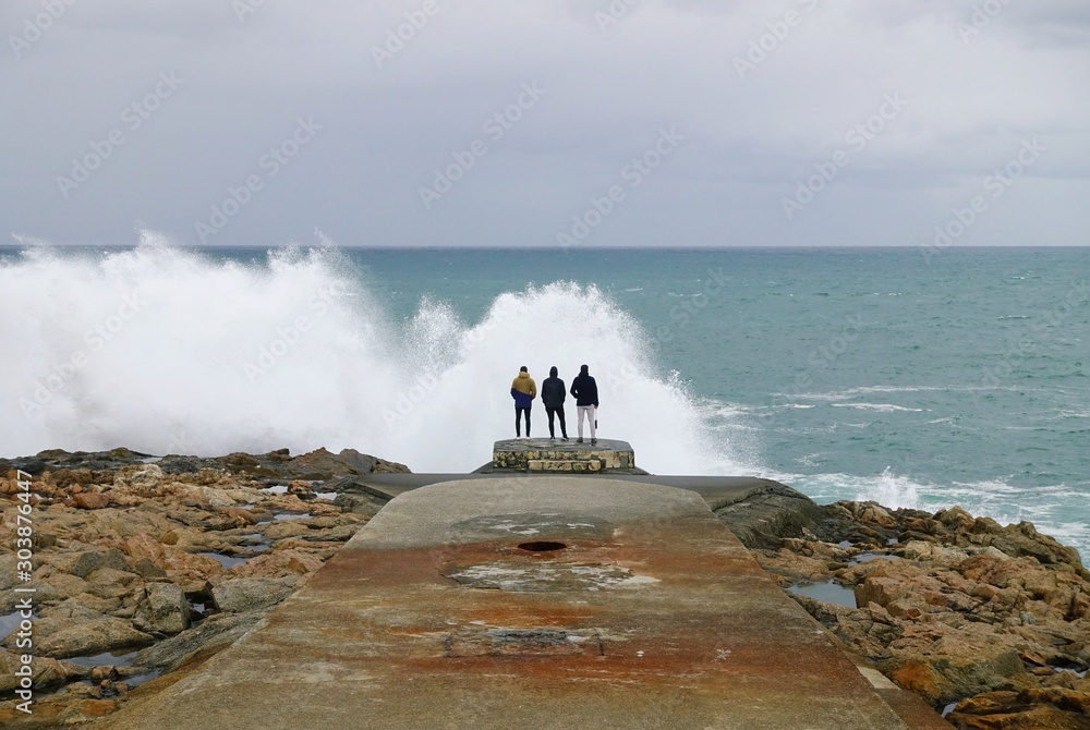 Unknown young people against the background of ocean waves Unknown young people against the background of ocean waves