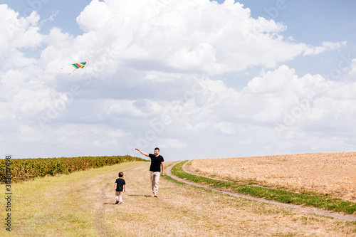 Dad and son walking outdoor,launch a kite on nature- Image
