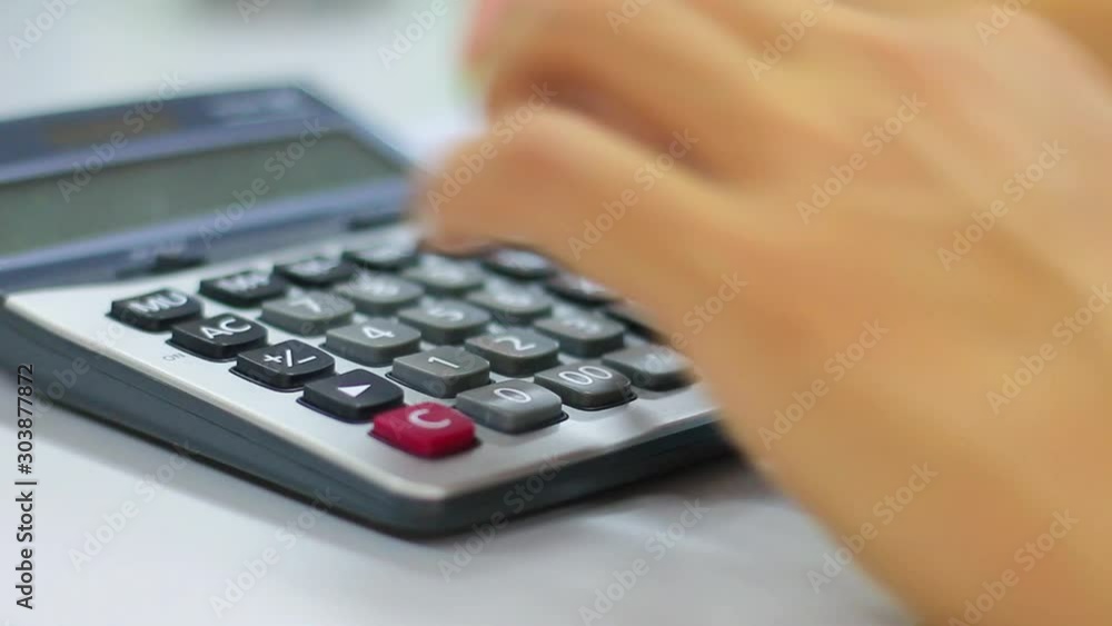 Business person uses calculator analysis financial data Business person uses calculator analysis financial data