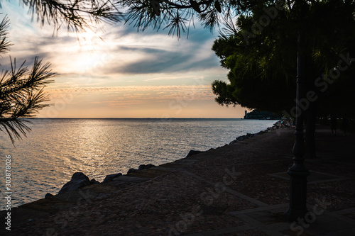 Dramatic view of the Mediterranean Sea coast at Trieste in Italy while sunset  with the miramare castle in the background.