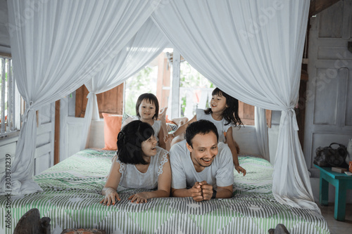 Asian happy family and child daughter relaxing on the bed enjoy holiday © Odua Images