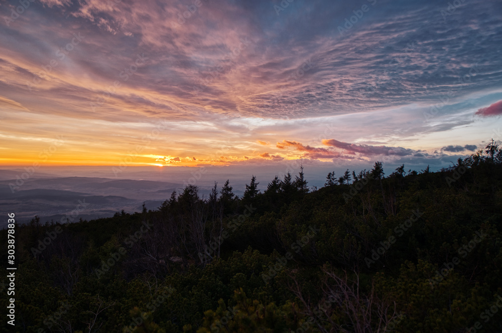 sunrise sun hidden behind clouds in mountains