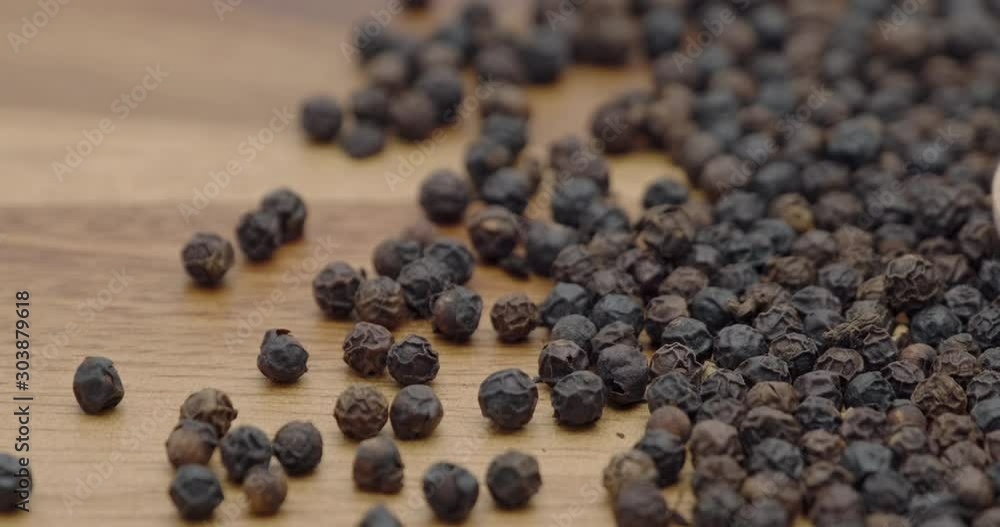 Truck shot of pile black peppers spread on chopper board Truck shot of pile black peppers spread on chopper board