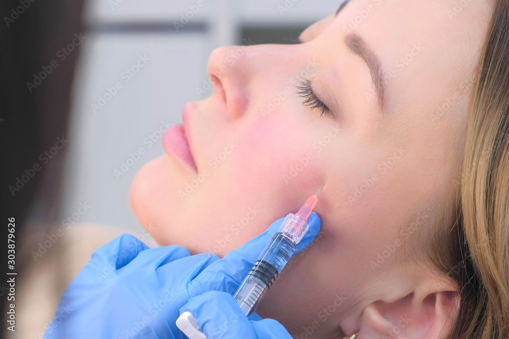 Ταπετσαρία Doctor cosmetologist making injection with filler in mature woman patient cheek on face to moisturize and rejuvenate skin, side view