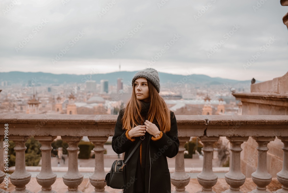 Φωτογραφία Young girl looking from Montjuic to Plaza de Espana including the four columns and the venetian towers in Barcelona, Spain