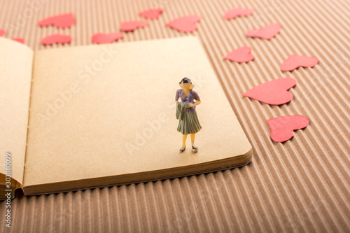 Woman figurine and Love concept with paper hearts photo