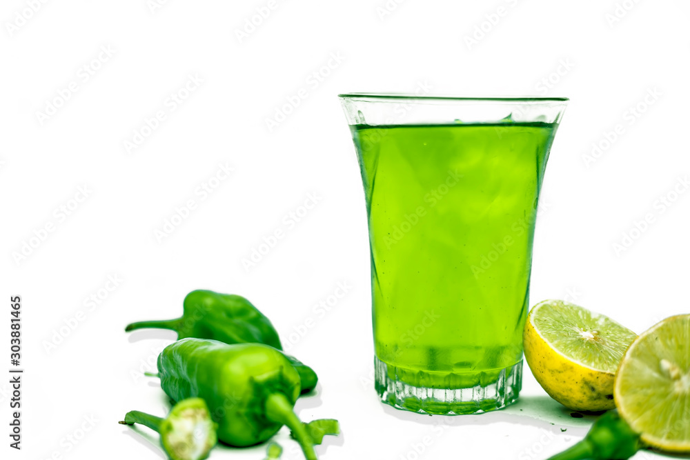 Φωτογραφία Close up shot of raw cut chilies with some sliced lemons isolated on white along with its chili flavored drink with it in a glass