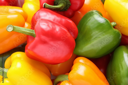 Fresh ripe colorful bell peppers as background, closeup photo