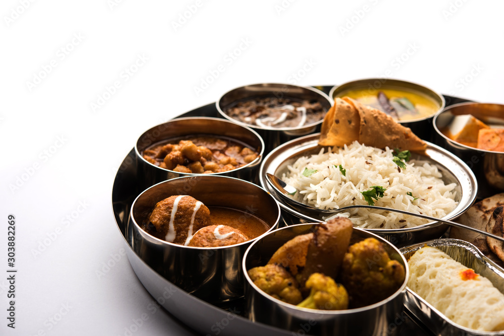 Indian vegetarian Food Thali or platter includes paneer butter masala, dal makhani / tarka, chole papad, kofta curry, gulab jamun, aloo-gobi sabji, chapati and rice with Bengali sweet served Indian vegetarian Food Thali or platter includes paneer butter masala, dal makhani / tarka, chole papad, kofta curry, gulab jamun, aloo-gobi sabji, chapati and rice with Bengali sweet served