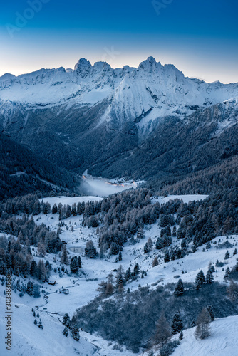 Mountain village in Alpine valley during sunrise / Ski resort village getting ready for winter season