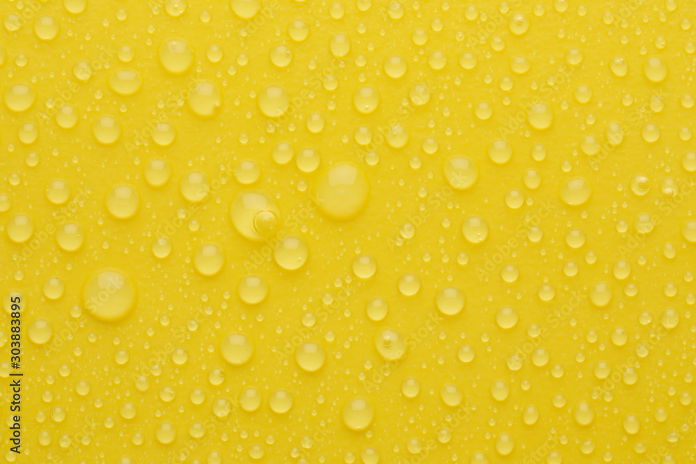 Water drops on yellow background, top view Water drops on yellow background, top view