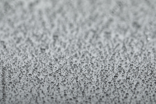 Water drops on light grey background, closeup view