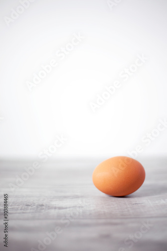 Whole brown egg solitary on gray wooden background