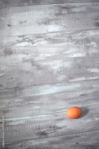 Whole brown egg solitary on gray wooden background