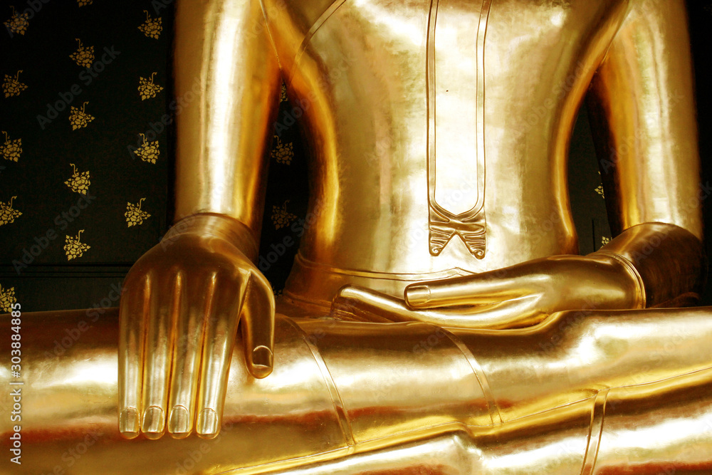 The hands of the golden meditating Buddha statue