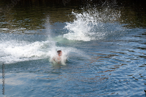 young man jumps into the water splashing water © sergiy1975