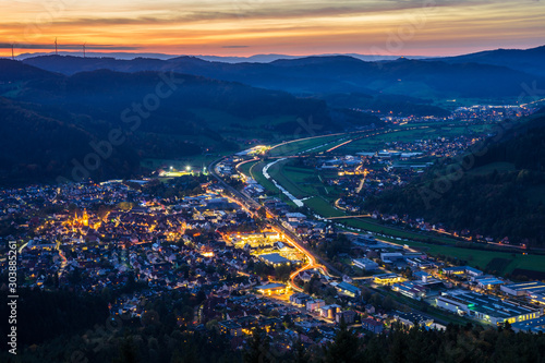 Germany, Black forest city haslach im kinzigtal houses, streets and cityscape illuminated by night, aerial view from above with red sky in perfect nature landscape