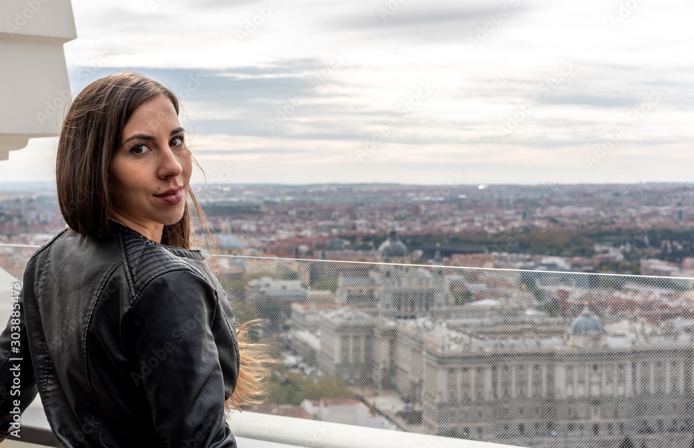 Girl looking at camera on a terrace, with the city in the background