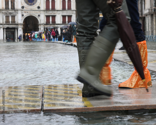 feet with boots and gaiters on the walkway in Venice Italy