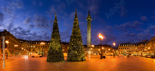 Panoramic view of Place Vendome with Christmas trees and holiday decorations at dusk. In the center, the Vendome column with the statue of Napoleon. 1st Arrondissement, Paris, France
