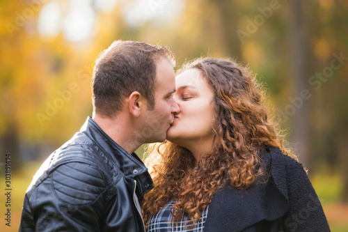 Happy couple kissing in autumn background