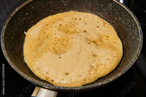 Cooking big pancake on frying pan