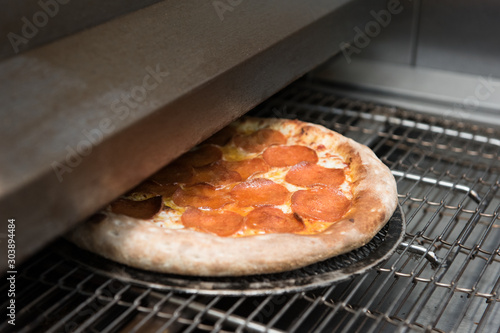 Preparing pizza in oven at ...