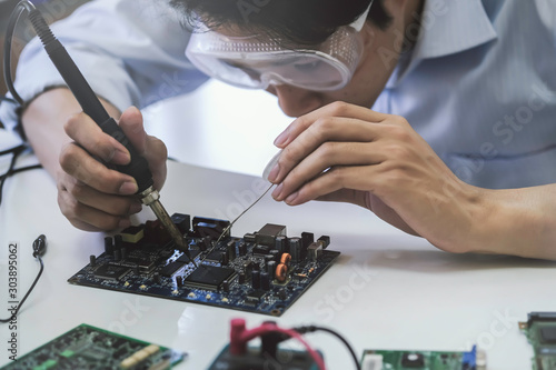 Принти на полотні Close up of the hand men hold tool repairs electronics manufacturing Services, Manual Assembly Of Circuit Board Soldering