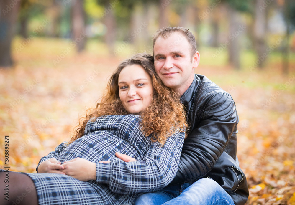 Happy pregnant couple  in autumn background