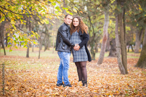Happy pregnant couple in autumn background
