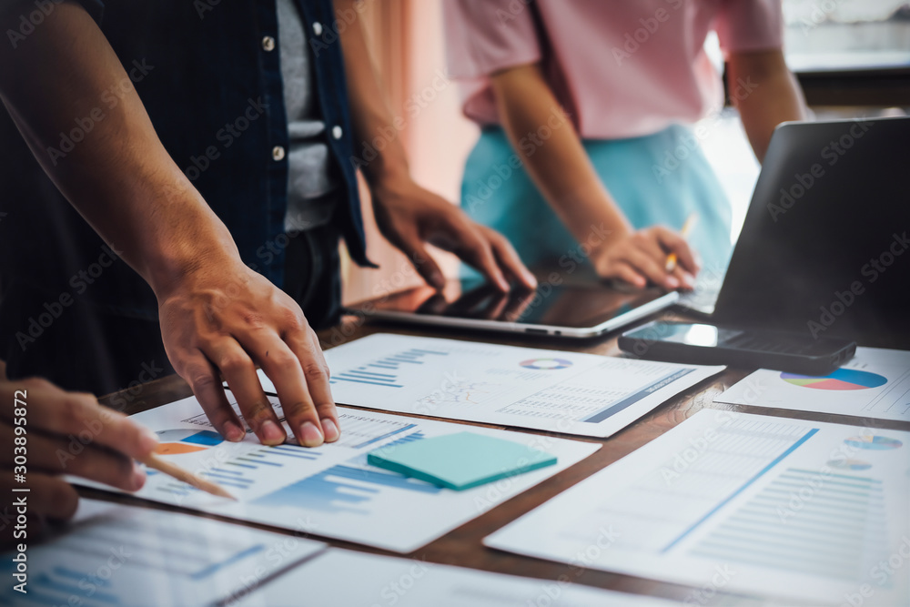 Asian business people meeting new startup project pointing graph discussion and analysis data charts and graphs.Business finances and accounting concept Asian business people meeting new startup project pointing graph discussion and analysis data charts and graphs.Business finances and accounting concept
