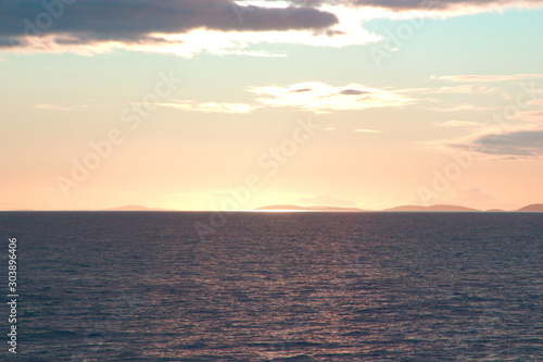 Image of the beautiful sunset hidden by clouds over the sea