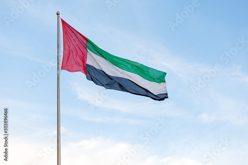 UAE flag waving in the sky, national symbol of UAE 