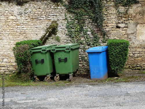 Waste sorting concept. Three trush cans near the stone wall