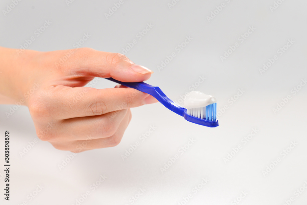 Woman holds toothbrush with toothpaste in her hand isolated on white background. Woman holds toothbrush with toothpaste in her hand isolated on white background.
