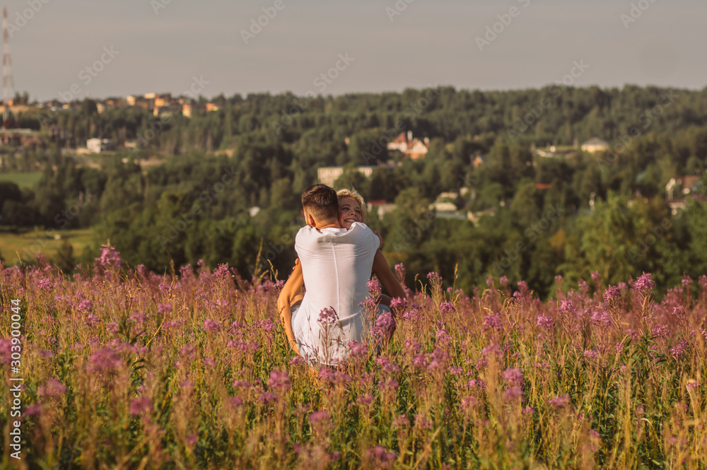 Φωτογραφία Young girl fool around and carry her boyfriend on hands in the field