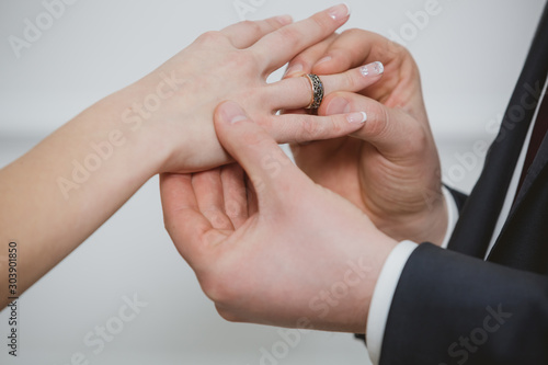 Groom put a ring on finger of his lovely wife.