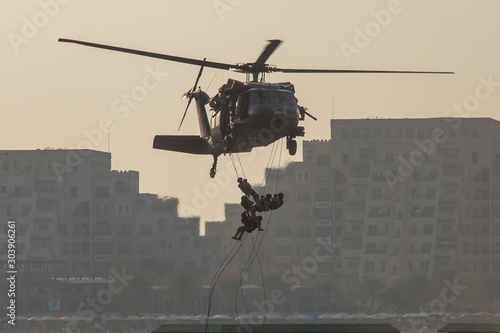 Fotografia Military combat and war with helicopter flying into the chaos and destruction