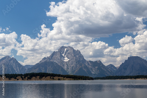 View of the Teton montains as a seen from a lake with a cloudy sky